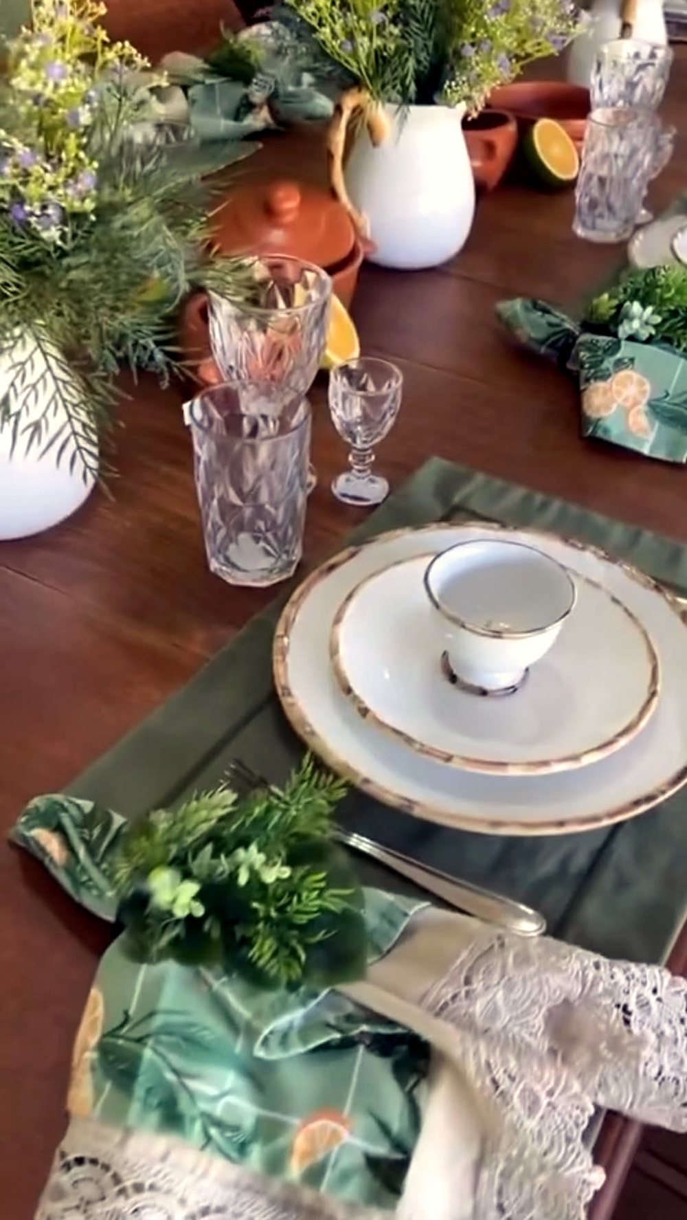 Mesa posta elegante com louças, taças e arranjo central